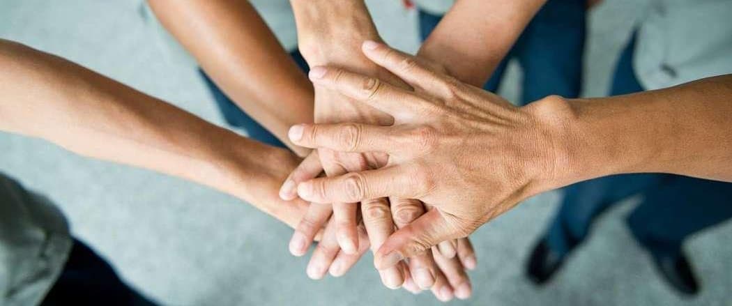 5 Personen legen rituell ihre Hand über die der anderen.