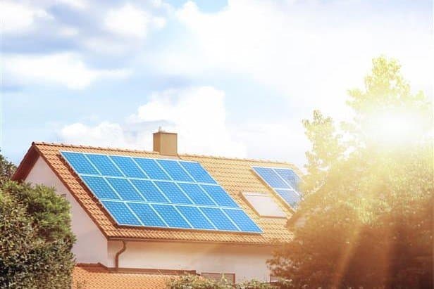 Sonne auf Dach mit PV-Anlage