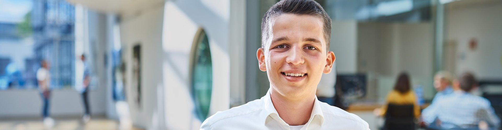 Mann steht im Sonnigen Atrium der Stadtwerke Verwaltung