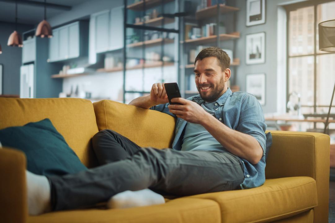 Mann auf Sofa am Handy