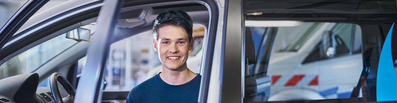 Mann sitzt mit einem Gerät in der Hand in einem Auto der Stadtwerke Witten.