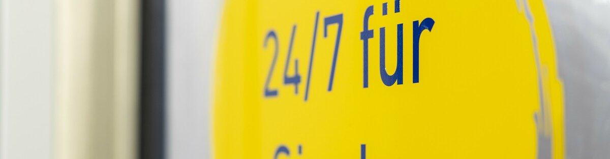 Sticker auf einem Glas mit der Aufschrift "24/7 für Sie da".